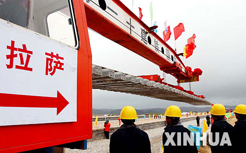 西藏境內(nèi)第一段鐵路軌排在安多火車(chē)站鋪下,鐵軌將從這里向拉薩繼續(xù)延伸(2004年6月22日攝)。 青藏鐵路從西寧至拉薩全長(zhǎng)1956公里,是世界上海拔最高、線路最長(zhǎng)、穿越凍土里程最長(zhǎng)的高原鐵路。把鐵路修進(jìn)西藏是幾代中國(guó)人的夢(mèng)想,但這一想法直到新中國(guó)成立后才逐漸變?yōu)楝F(xiàn)實(shí)。青藏鐵路一期工程西寧至格爾木段于1958年開(kāi)工,1984年交付營(yíng)運(yùn)。但限于當(dāng)時(shí)國(guó)家的經(jīng)濟(jì)實(shí)力以及高原、凍土等筑路技術(shù)難題尚未解決,格爾木至拉薩段被迫停建。2001年6月,國(guó)家總投資330.9億元?jiǎng)庸ば藿ㄇ嗖罔F路二期工程。這一工程跨越昆侖山、唐古拉山,通過(guò)多年凍土層和大片“生命禁區(qū)”,是人類(lèi)鐵路建設(shè)史上亙古未有的穿越。它的建成將為神秘而古老的青藏高原帶來(lái)新的生機(jī)和活力! 新華社發(fā)